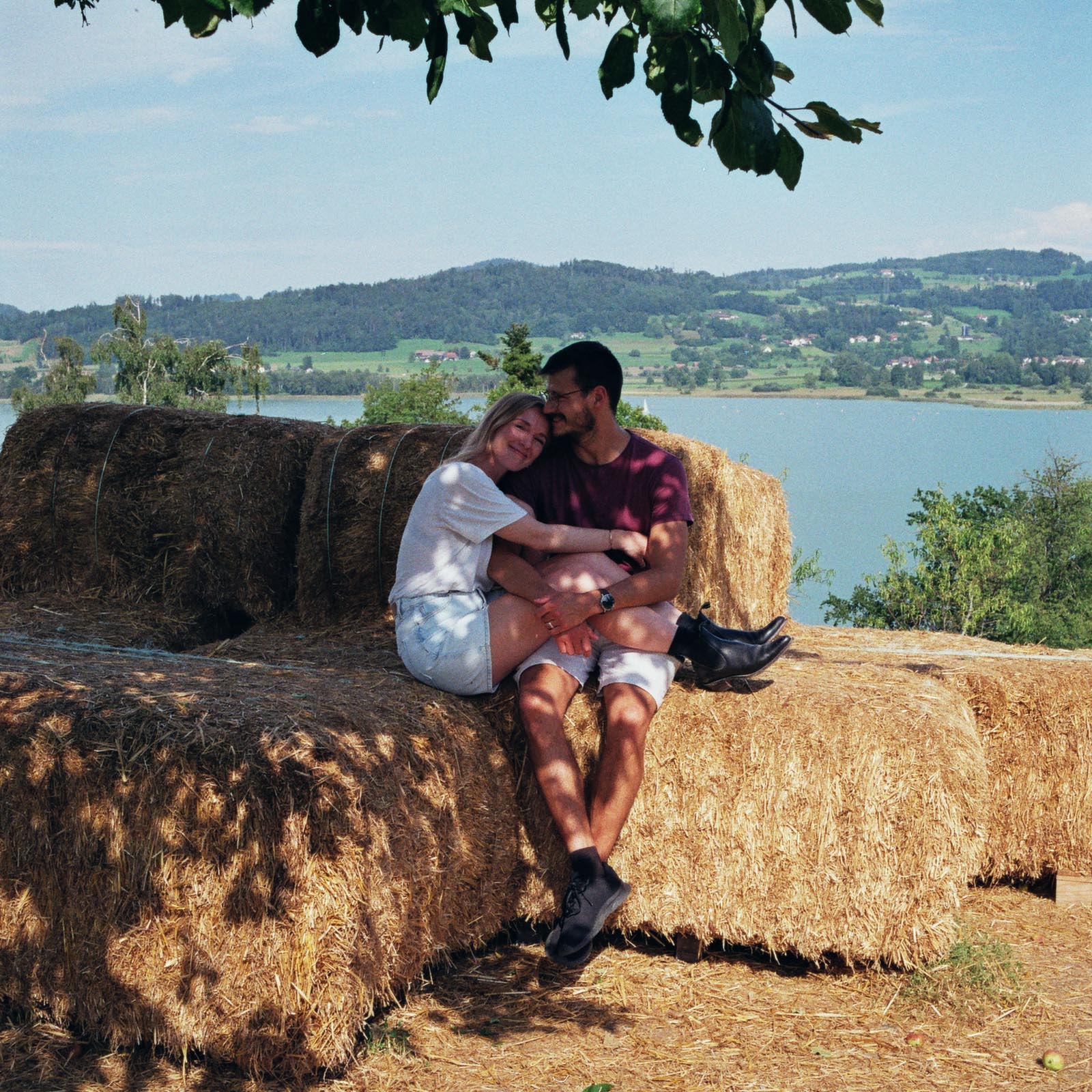 couple hugging and sitting on a straw bale