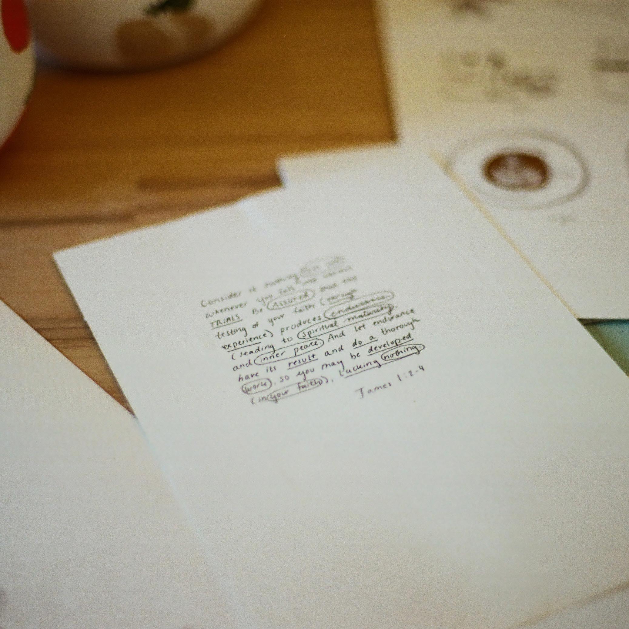 piece of paper laying on a table with a bible verse written on it