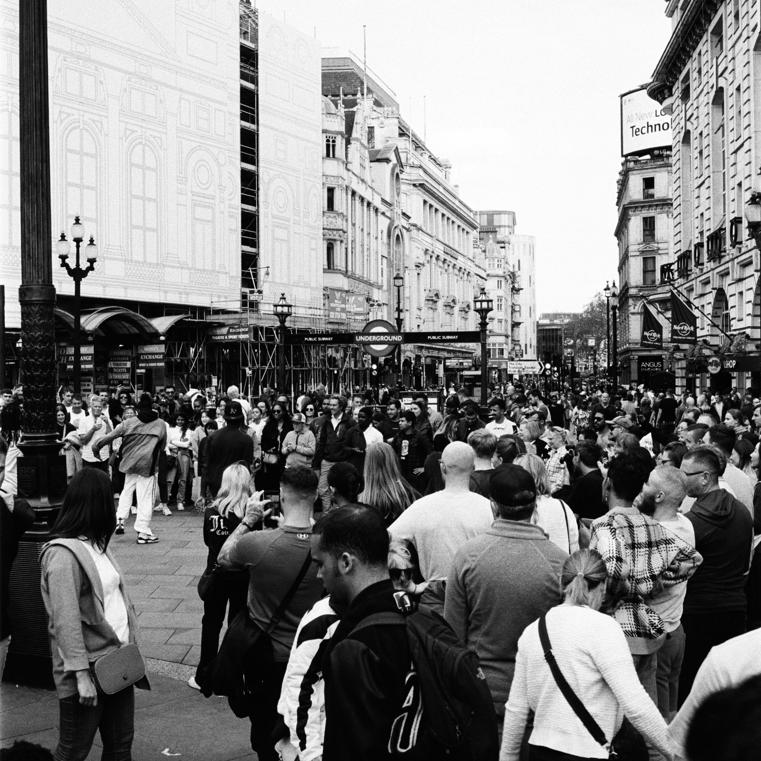 a lot of people surrounding a group of dancers at a public square