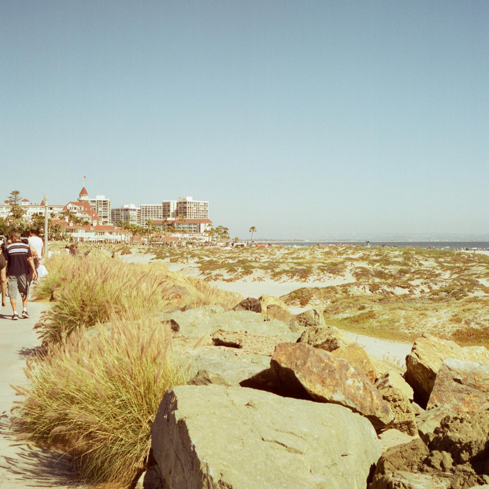 beach coastline with stones in front and buildings in the distance