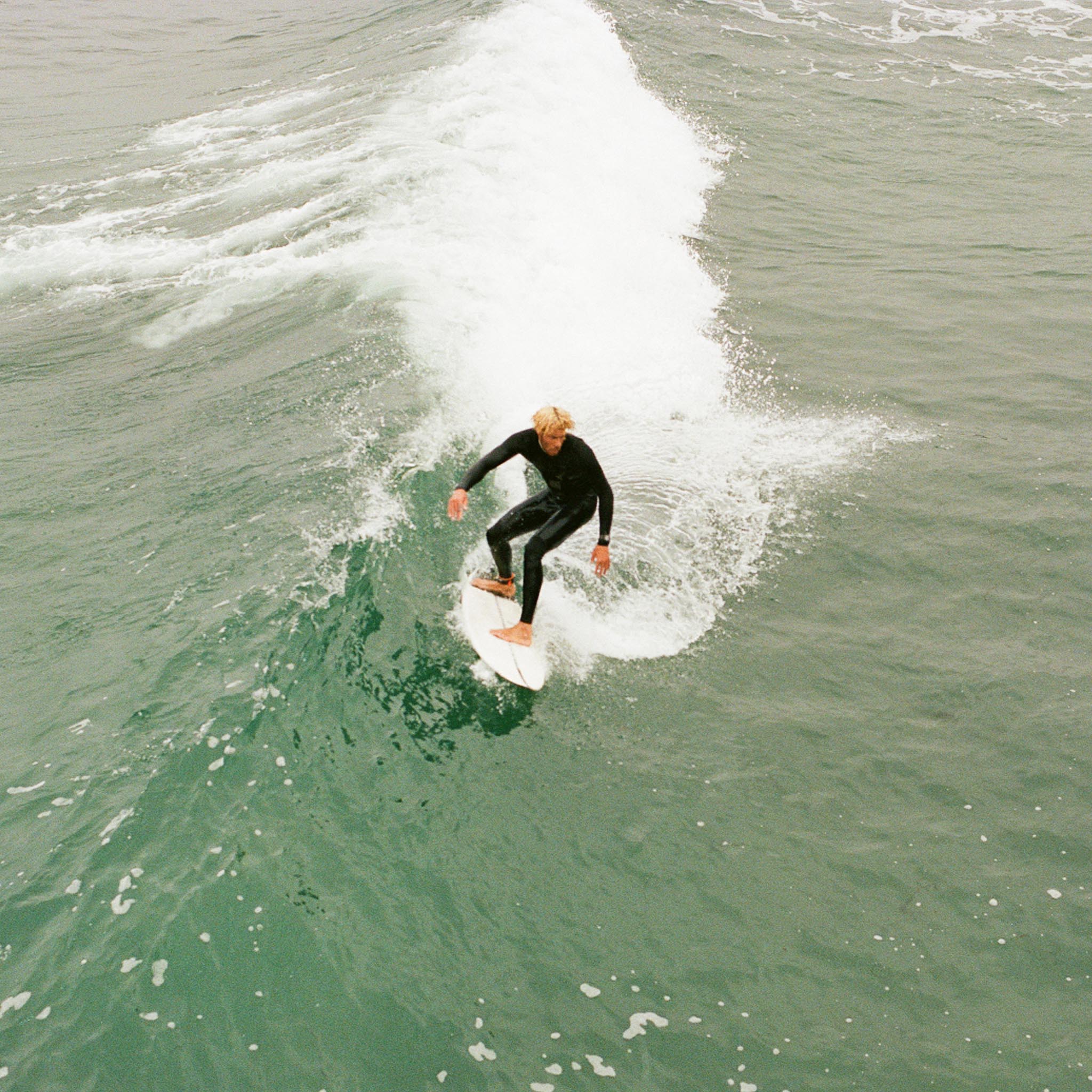 surfer in a wetsuit riding a wave in the sea