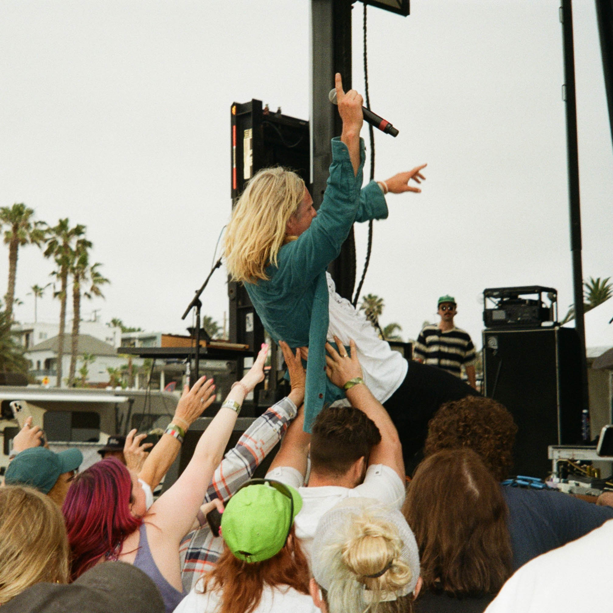 lead singer from the band Switchfoot leaning back into the crowd during a concert