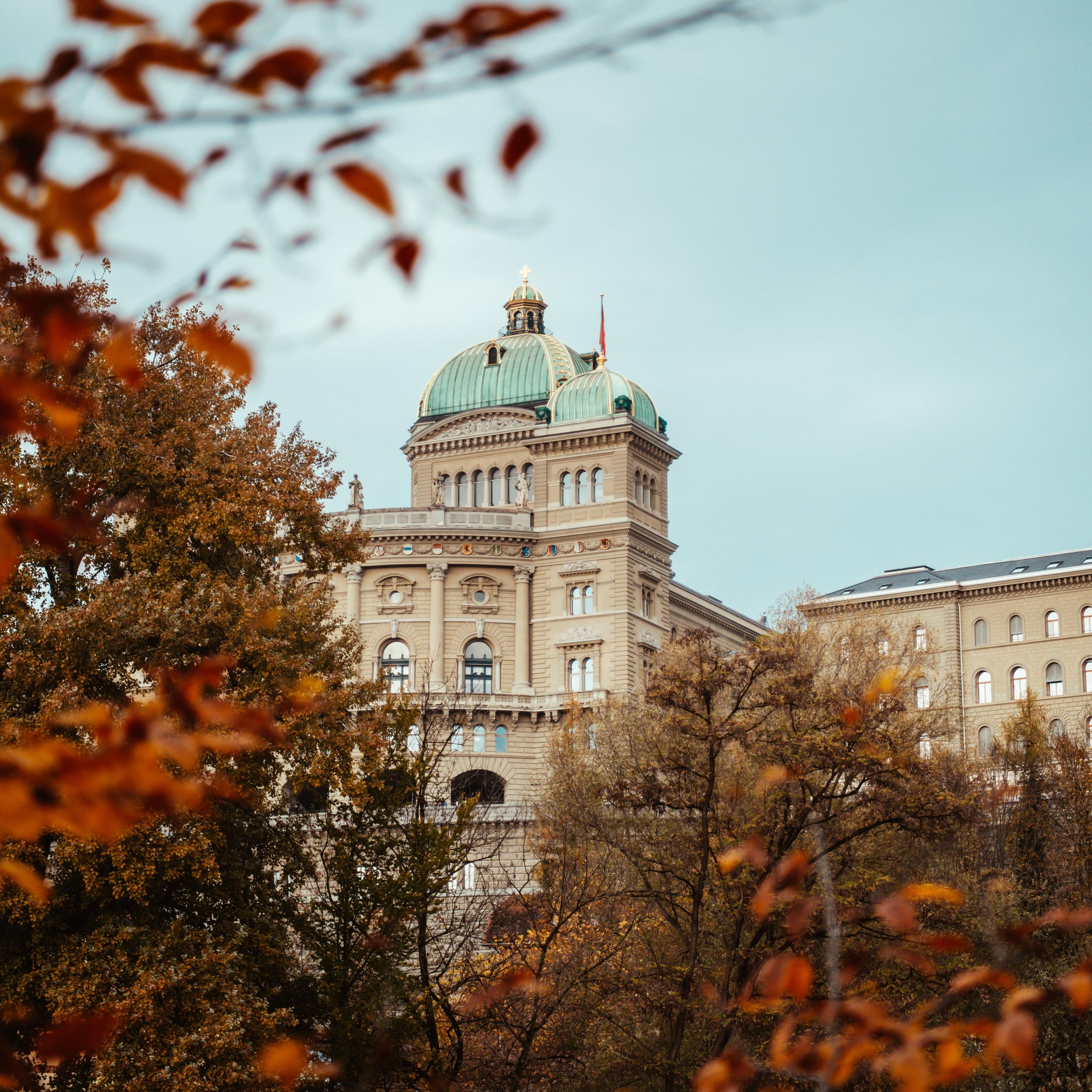 swiss government building with trees in fall colors