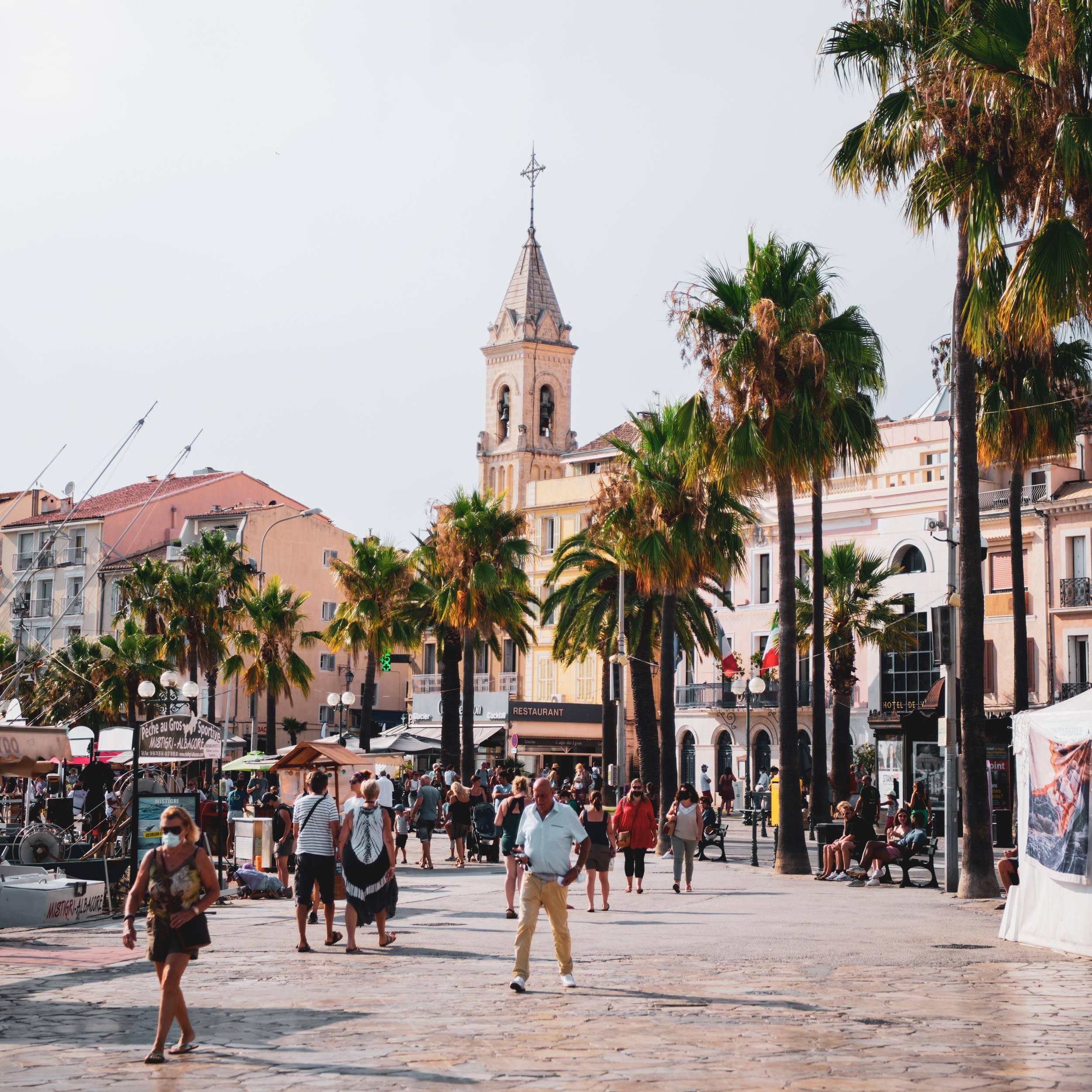 square in a Mediterranean city with palms and people walking