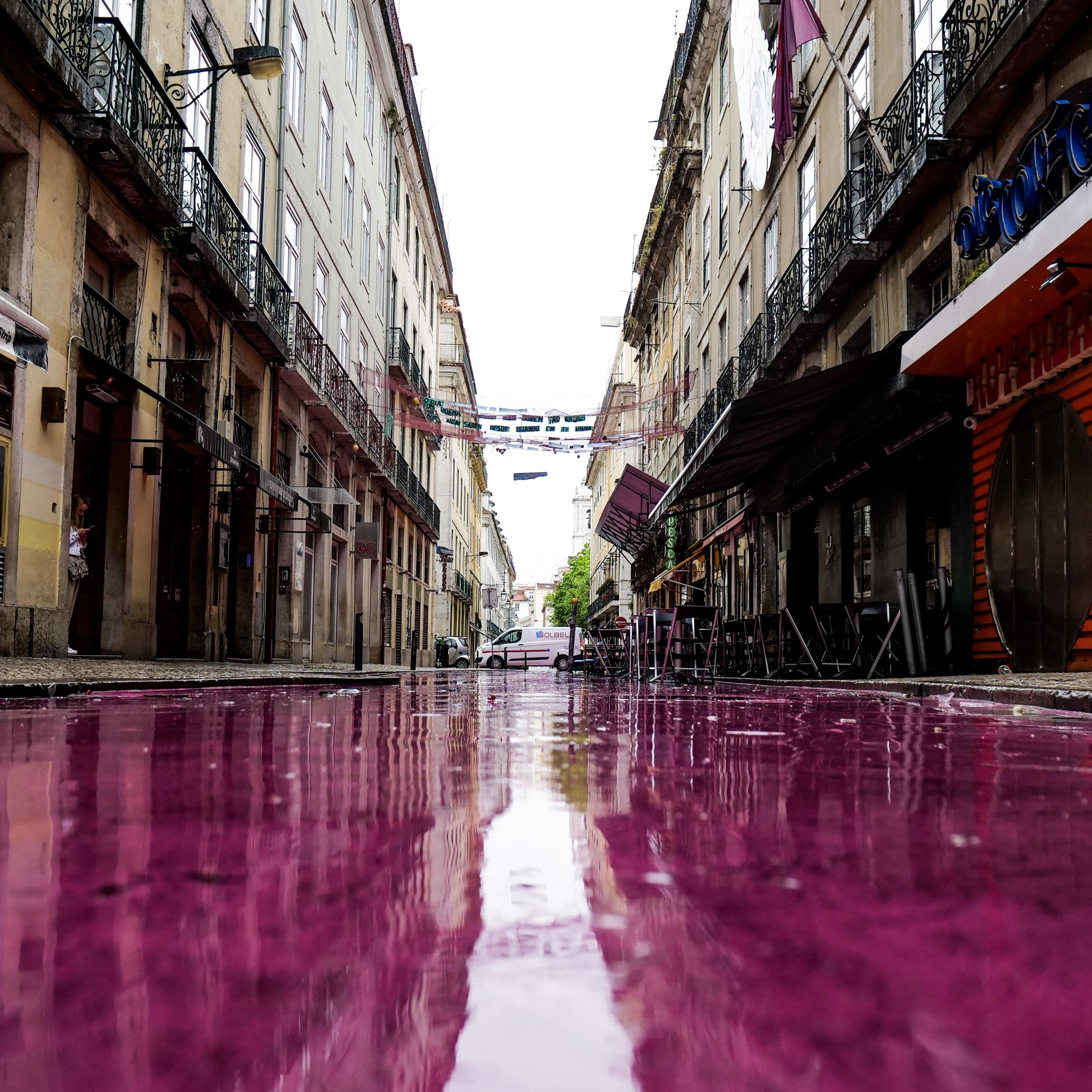 pink, water-covered floor in which the buildings are reflected