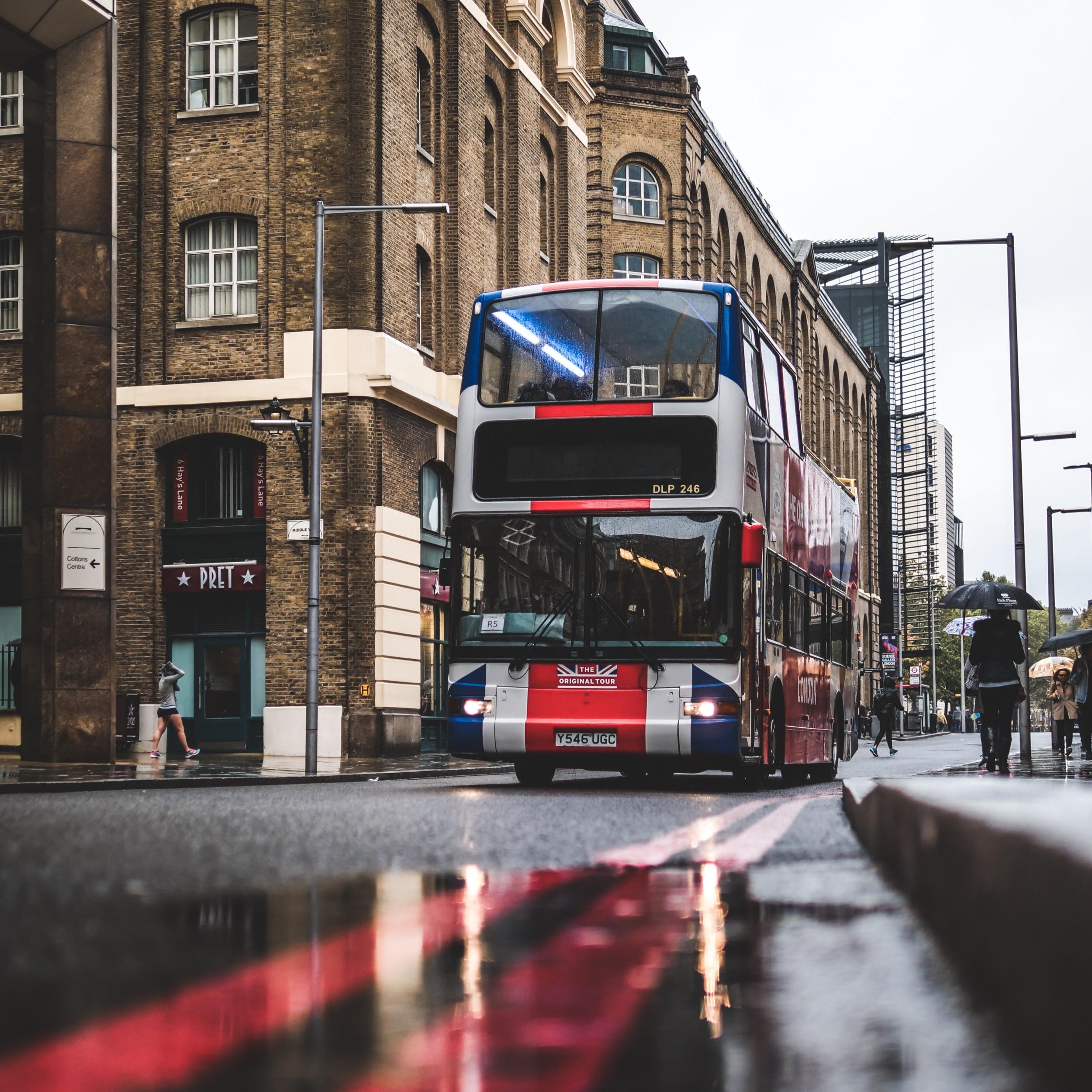 double-decker bus on a road with puddles of rain