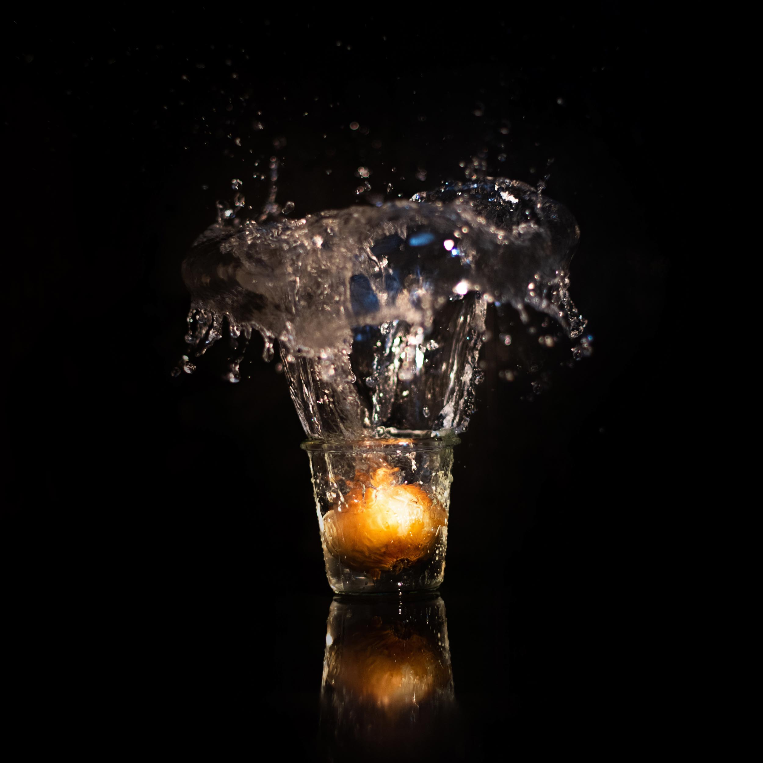 onion in a glass that splashes the water upwards