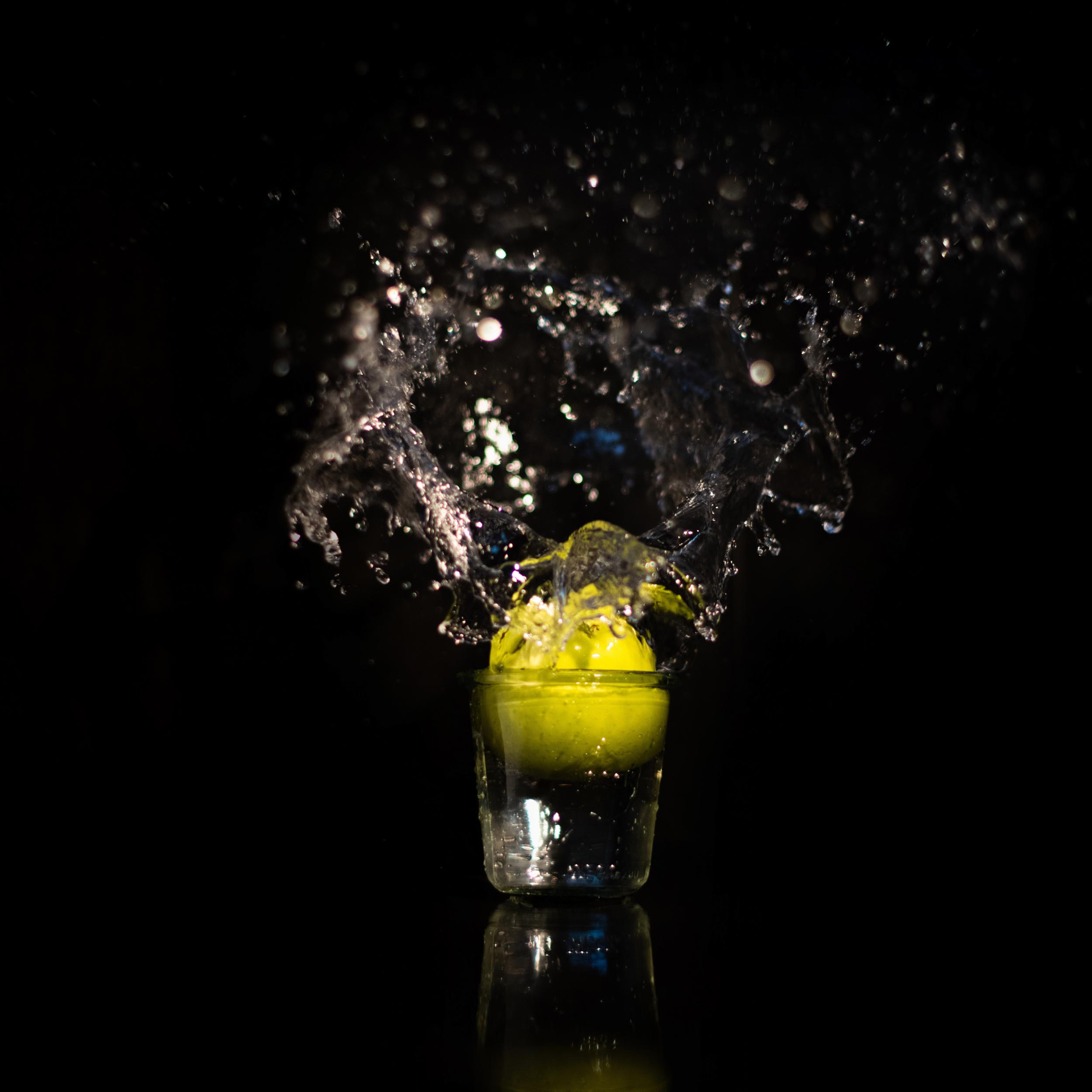green apple in a glass that splashes the water upwards