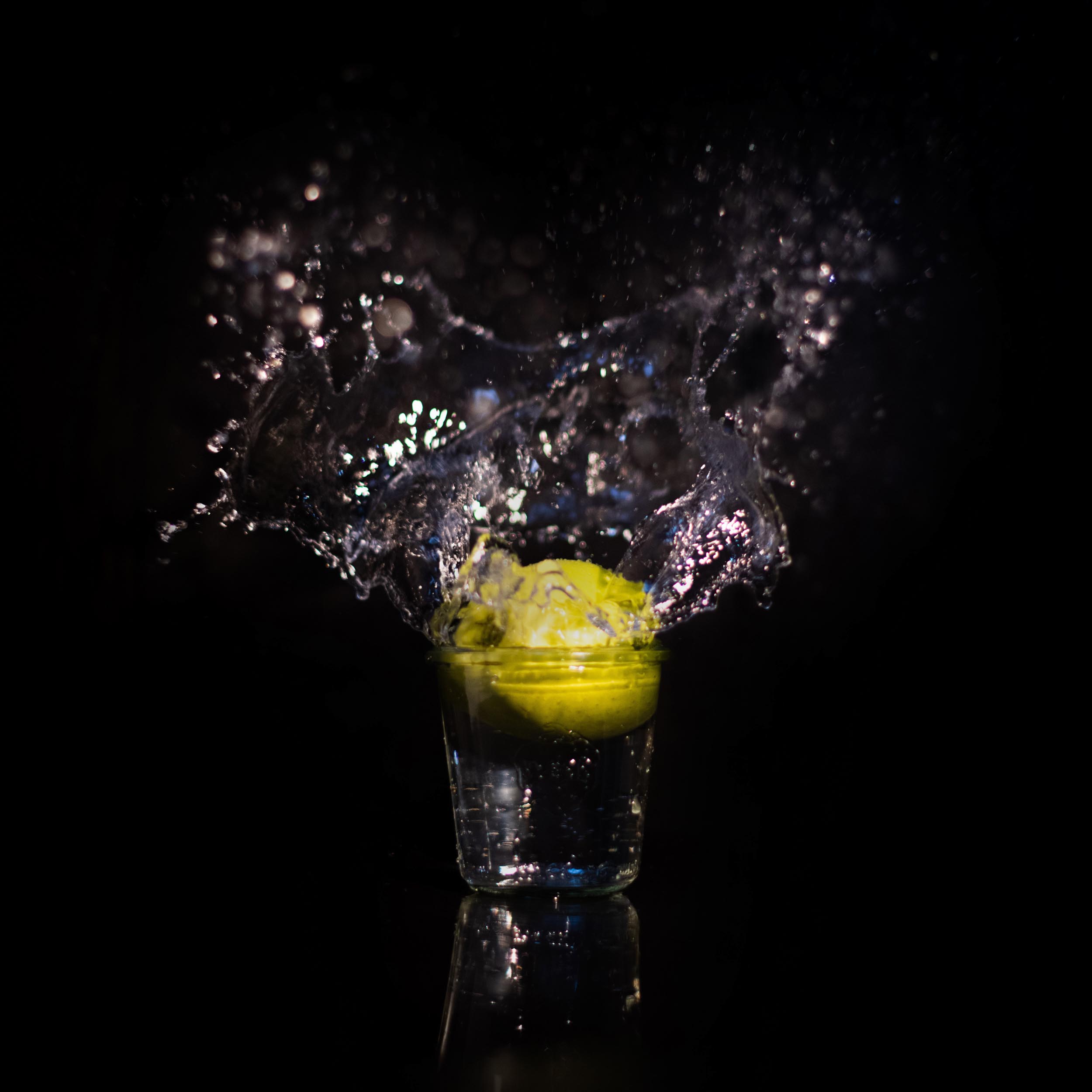 green apple in a glass that splashes the water upwards