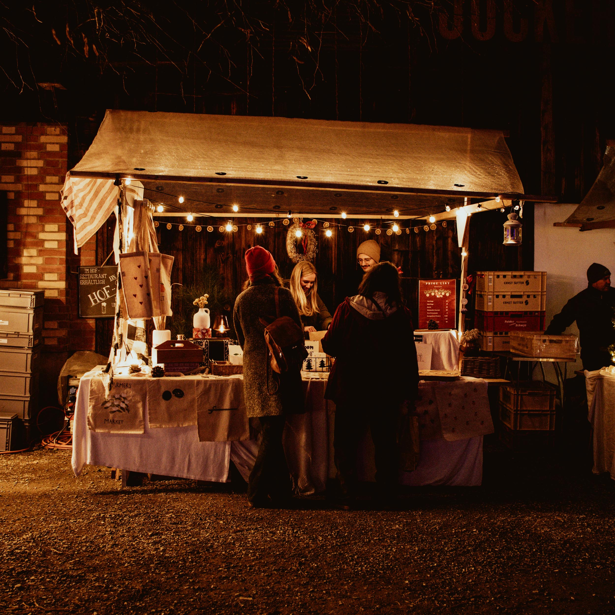 decorated christmas market stall during the night with people standing in front